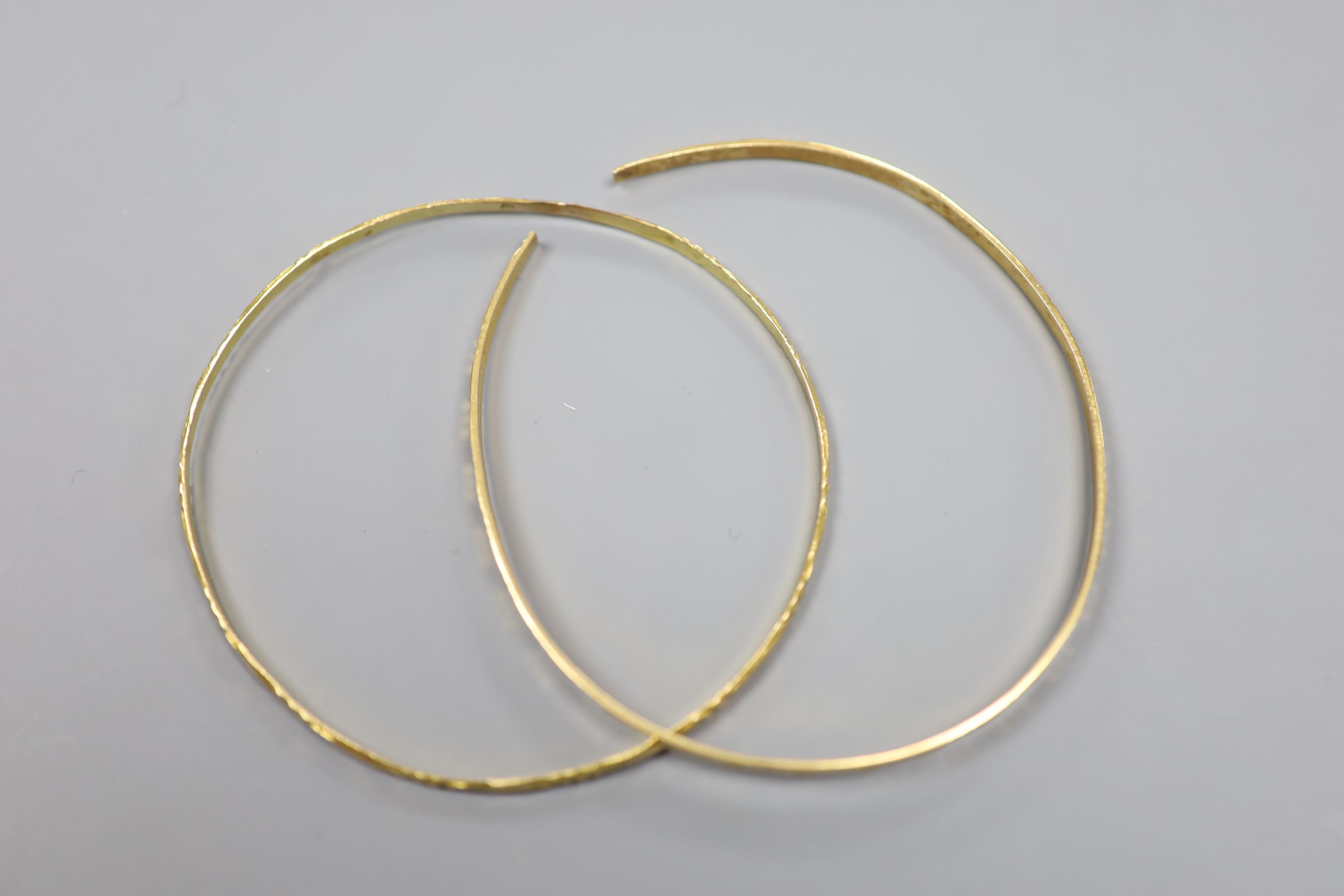 Two Middle Eastern yellow metal bangles (one cut)